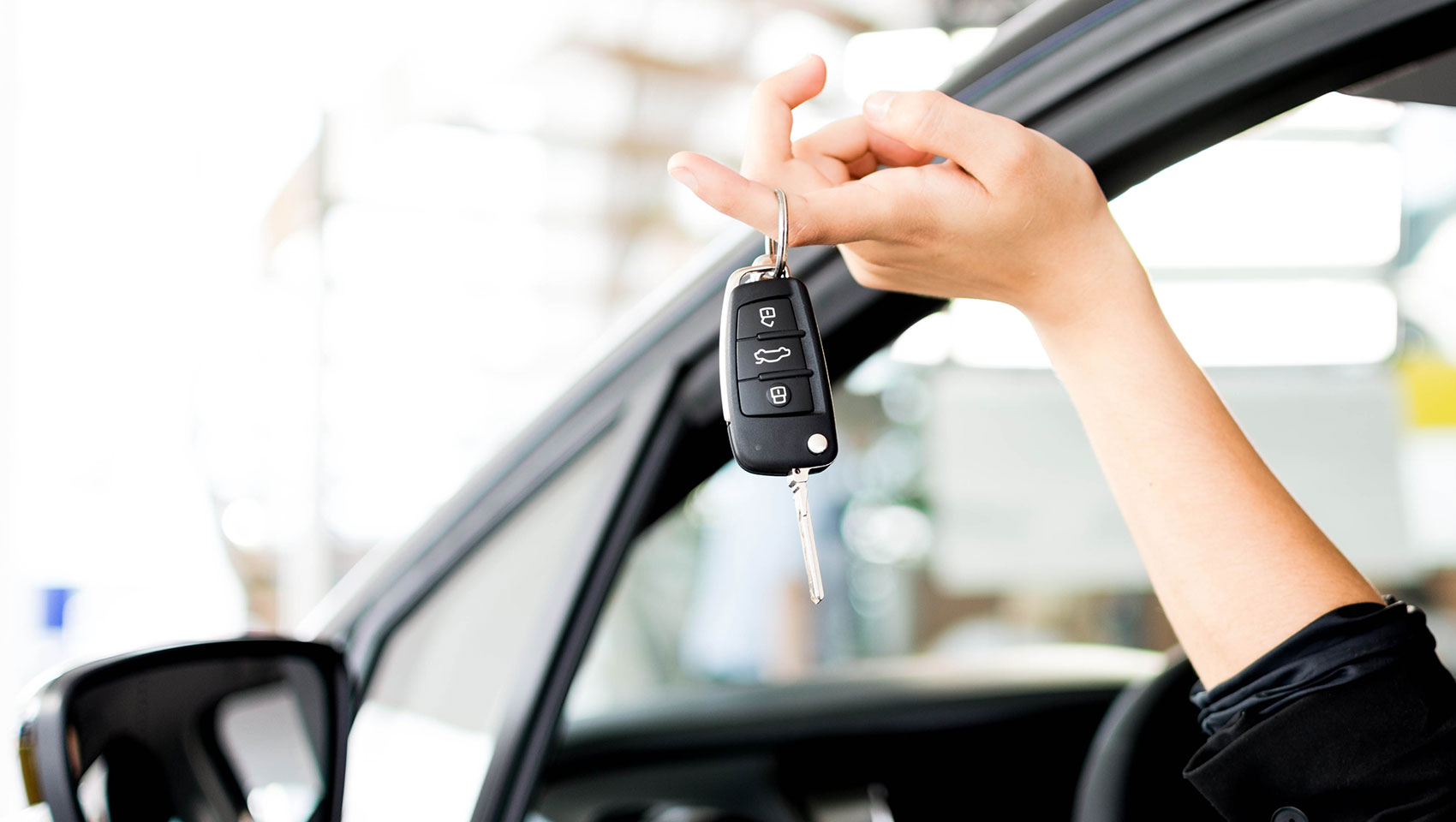 woman holding keys out car window