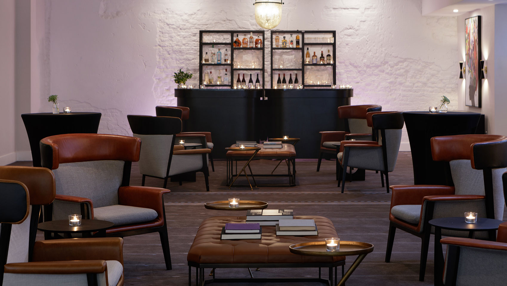 Intimate lounge style room set up with a bar and tea light candles