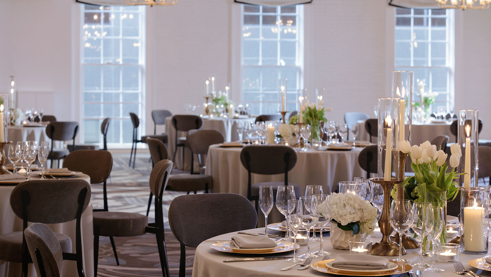 Hotel ballroom set up with tables with floral arrangements and candles