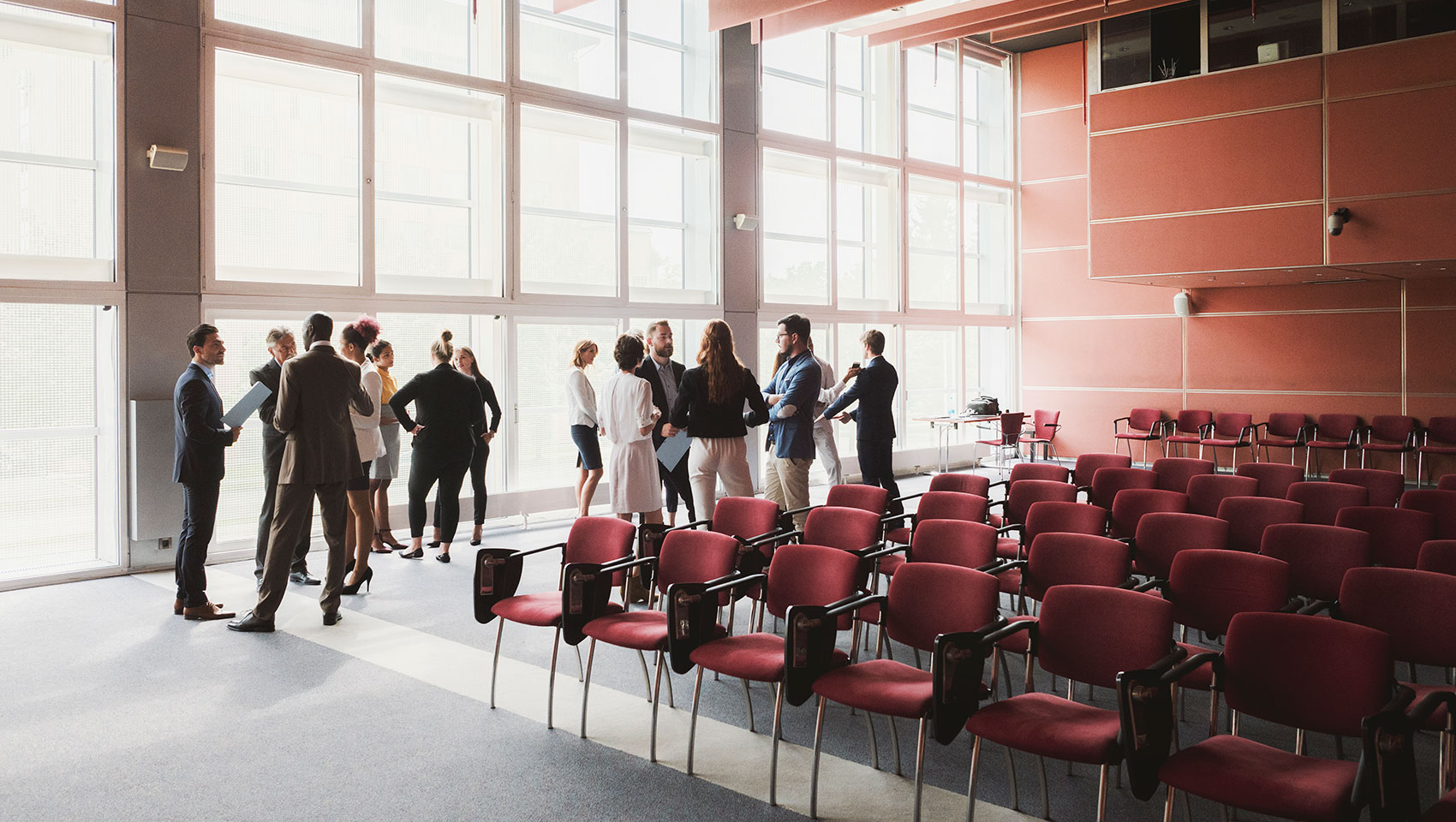 Business men and women speaking in convention room