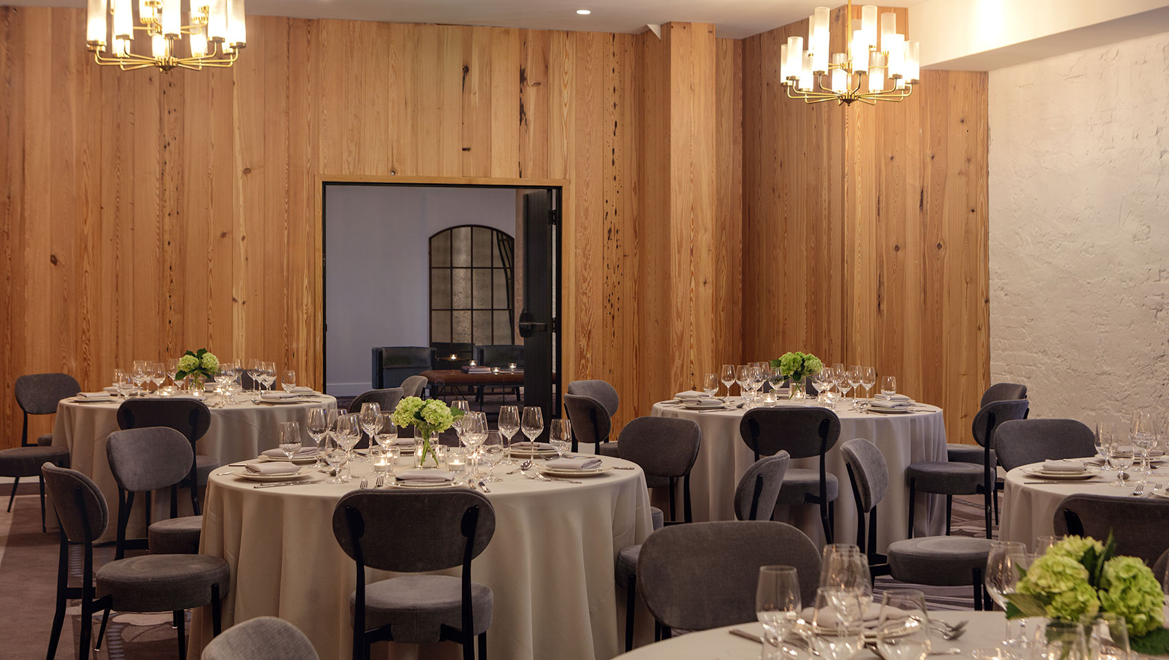 Hotel conference room set up with round tables and place settings