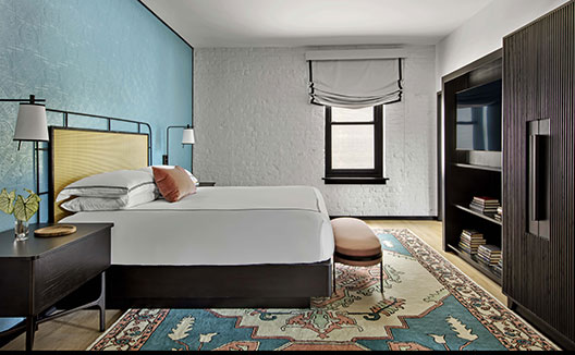 The Fiddle Suite at Hotel Fontenot image shows a plush king bed and a settee with a desk and chair
