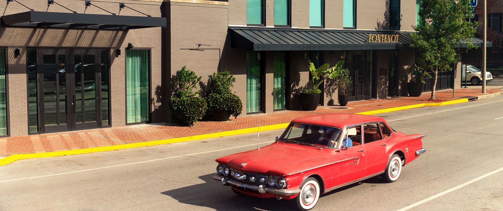 Red classic car on the street in front of Hotel Fontenot